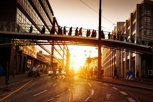 Personen, die über eine Brücke gehen, im Gegenlicht.